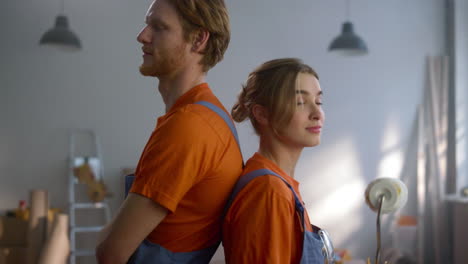 una pareja feliz mirando a la cámara durante la reparación del hogar. concepto de renovación diy.