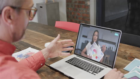 hombre de negocios caucásico en una llamada de video portátil con una colega afroamericana en la pantalla