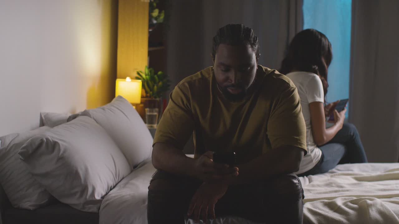 pareja con problemas de relación en casa por la noche ambos mirando teléfonos móviles en el dormitorio 10