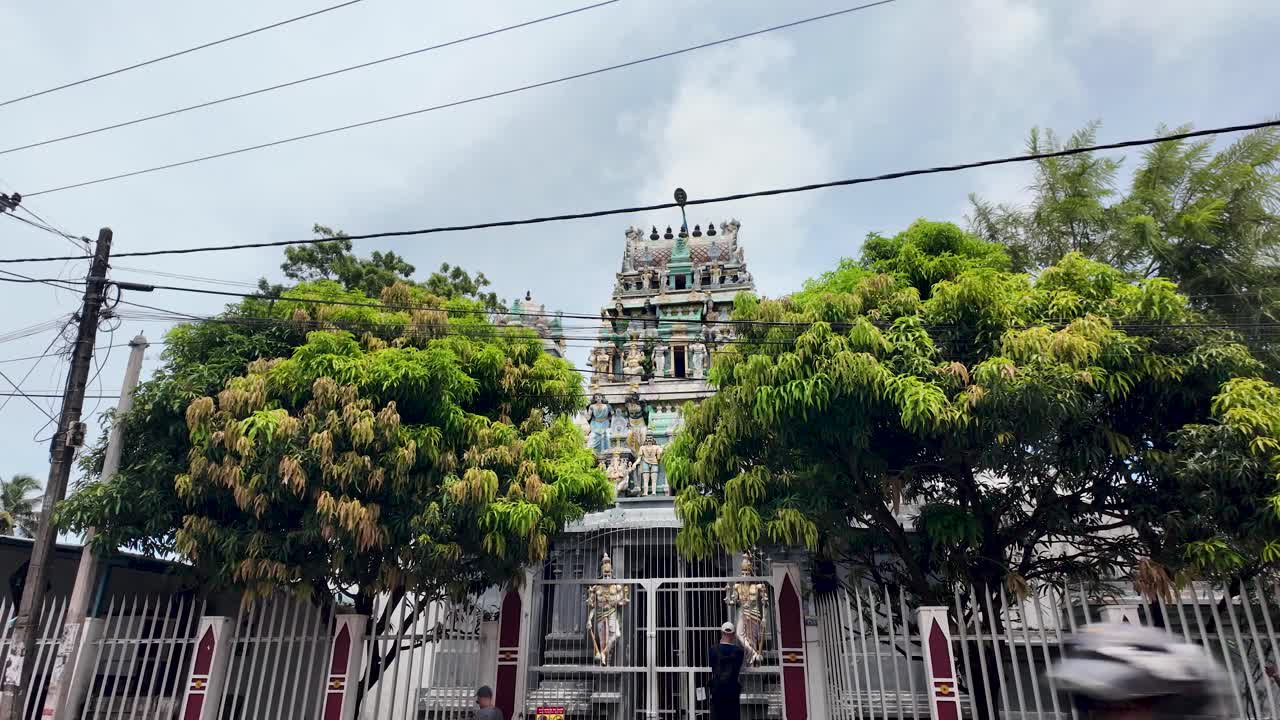 Hindu temple, surrounded by lush greenery, seen from the roadside in Negombo, Sri Lanka, showcasing beautiful architecture and cultural heritage.