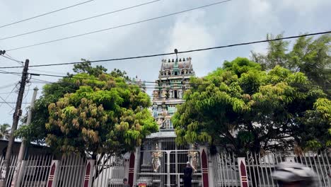 hindu temple, surrounded by lush greenery, seen from the roadside in negombo, sri lanka, showcasing beautiful architecture and cultural heritage.