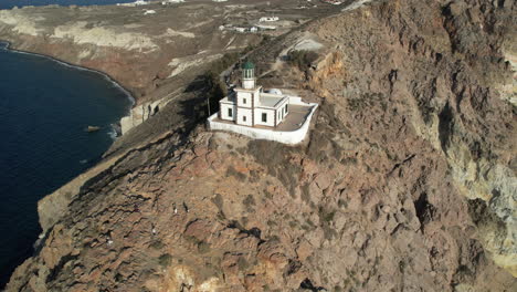 vista aérea del faro en la costa de la isla de santorini, grecia, disparo de drone
