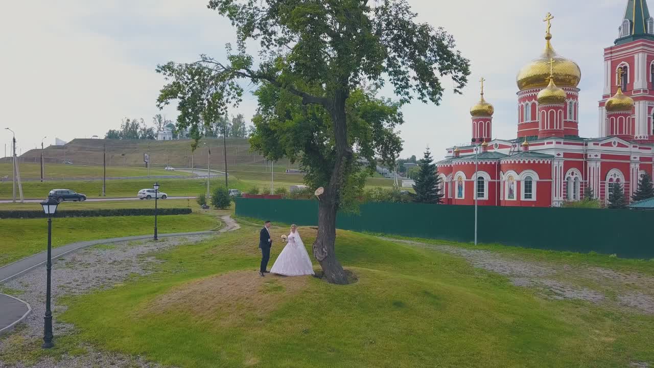 신부 와 신랑 은 교회 에 비해 나무 근처 에서 춤 을 추고 있다
