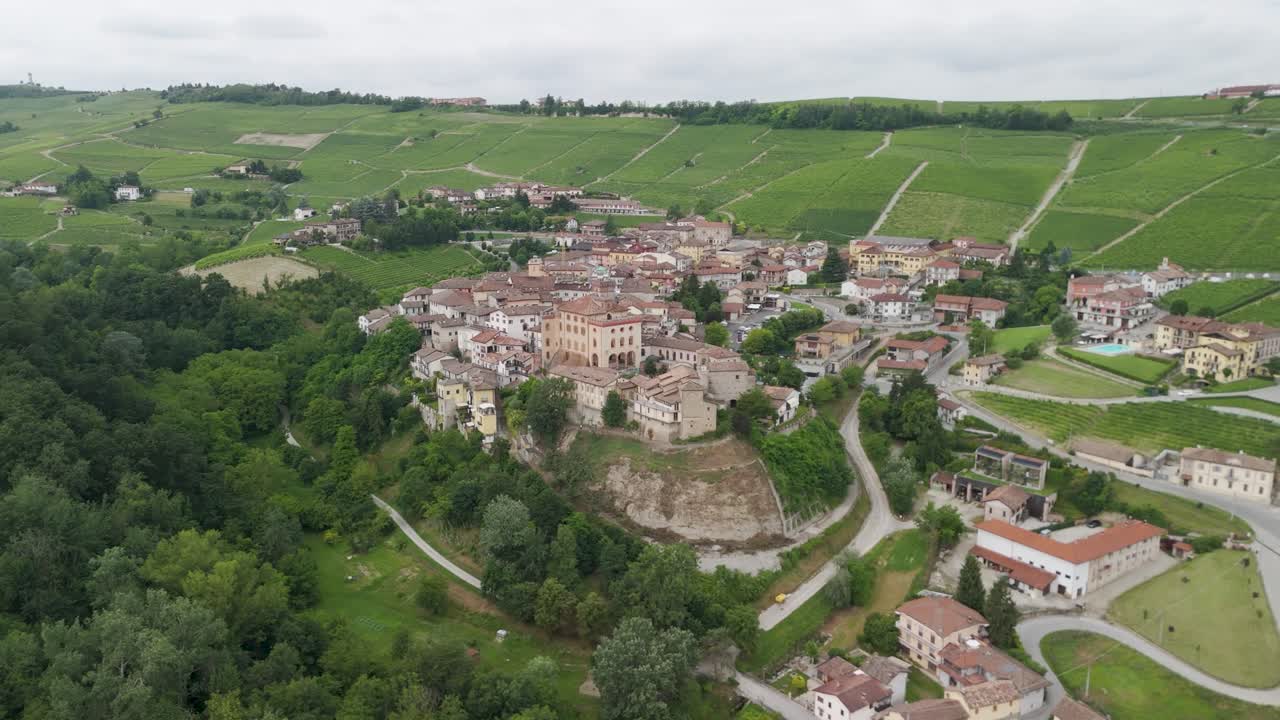 Barolo Castle in Langhe Wine Region, Cuneo, Piedmont, Italy. 4K Aerial view of the village and the vineyards circling to the left