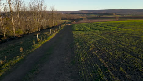 Antena-Sobre-La-Carretera-De-La-Granja-Y-Elevándose-Sobre-Los-Campos-En-La-Zona-Rural-De-Pensilvania.