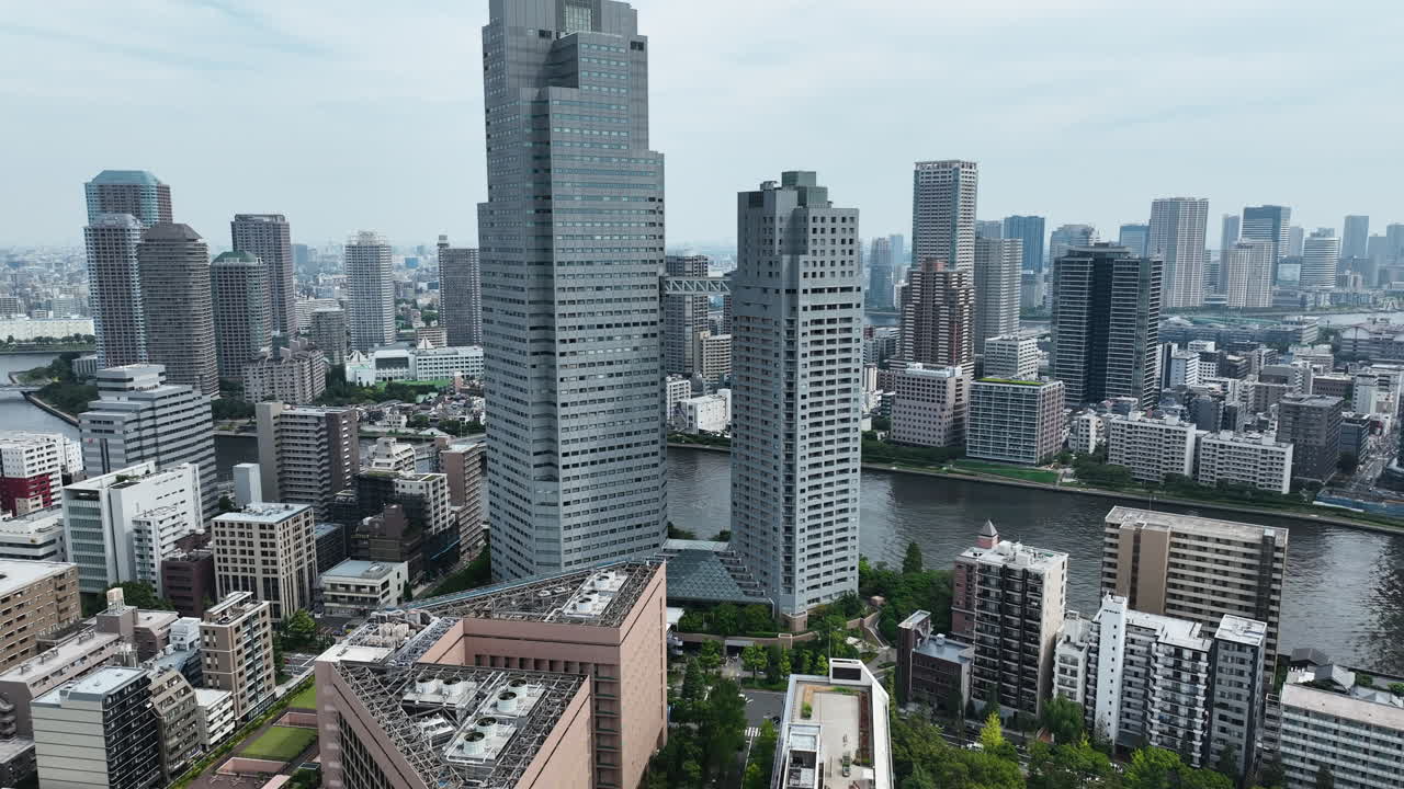 Modern Cityscape With Tall Buildings On The Banks Of Sumida River In Tokyo, Japan. wide drone shot