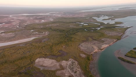 Aerial-drone-shot-flying-over-beautiful-stream-near-green-landscape