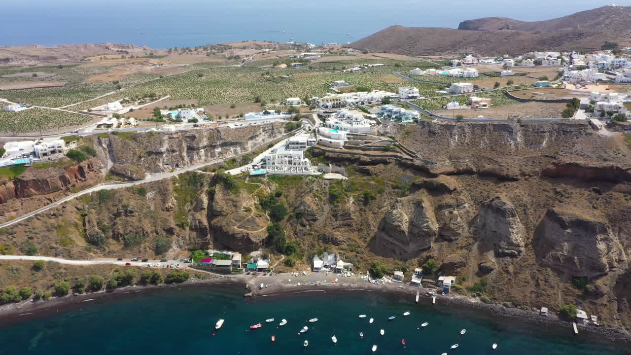 그리스 산토리니(santorini) 해변에 있는 지중해의 빌라와 어선이 있는 바위 절벽, 그리스 섬을 향해 공중 비행