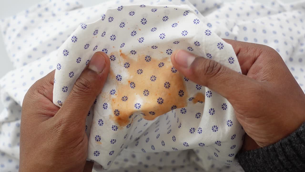 primer plano de una mancha en una camisa blanca