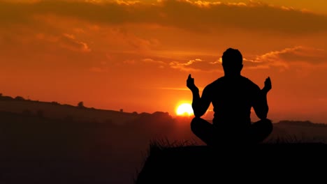 man meditating at sunset