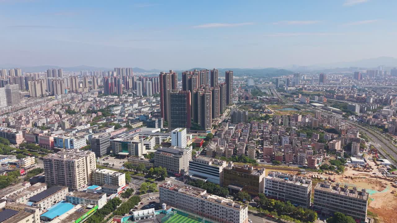 A vast aerial of the Shenzhen outskirts skyline. Captures the intense urban sprawl and development, contrasting the core high-rises with surrounding lower-density areas and open lots. China, UHD