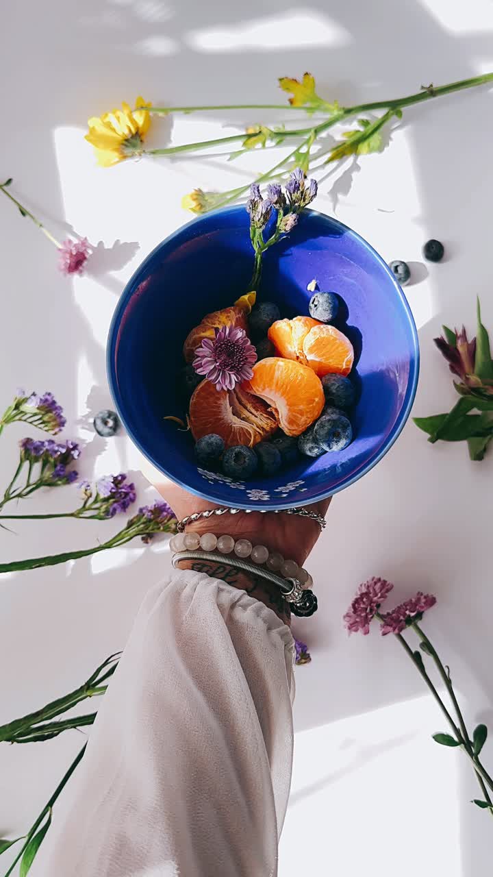 mano sosteniendo un plato de ensalada de frutas frescas con flores
