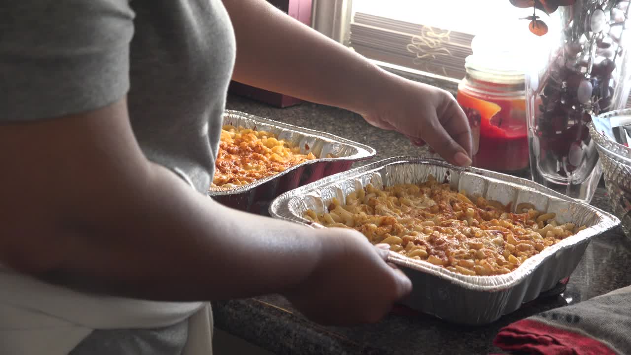 Woman Preparing Two Dishes of Baked Mac and Cheese