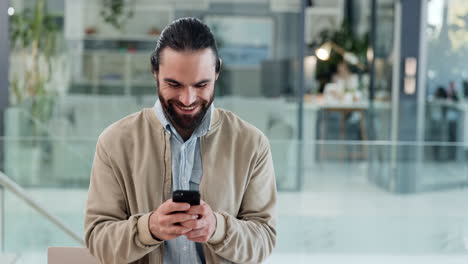 Young-business-man-typing-on-phone-in-an-office