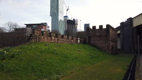 Restos-De-Mamucium-O-Mancunium-Y-Recreación-De-Un-Fuerte-Romano-En-El-área-De-Castlefield-De-Manchester-En-El-Noroeste-De-Inglaterra,-Reino-Unido-Mostrando-La-Torre-Betham-En-El-Fondo