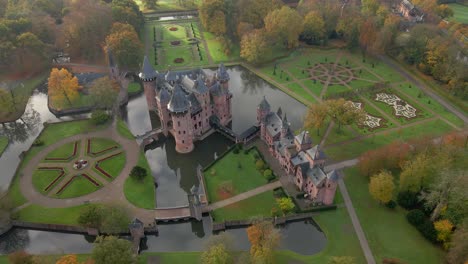 Aéreo-En-El-Mágico-Castillo-Medieval-De-Haar-Con-Jardines-Públicos-Al-Amanecer