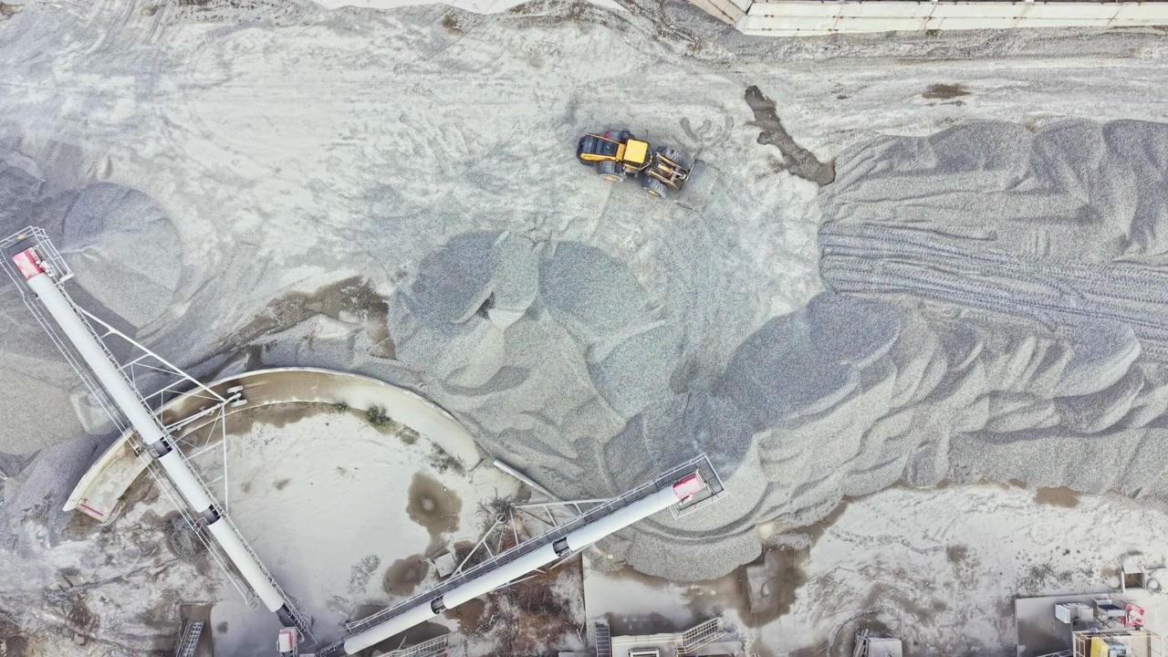 Granite quarry operation showing large machinery and piles of stone in a working site