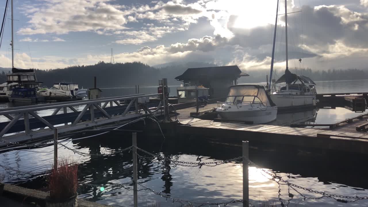 화창한 오후에 물 위에 보트가 있는 선착장, 긴 패닝 샷