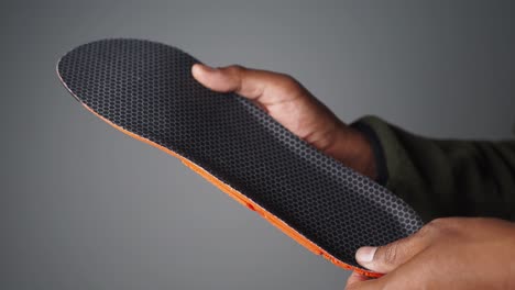 person holding a custom shoe insole