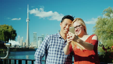 couple take selfie before toronto skyline