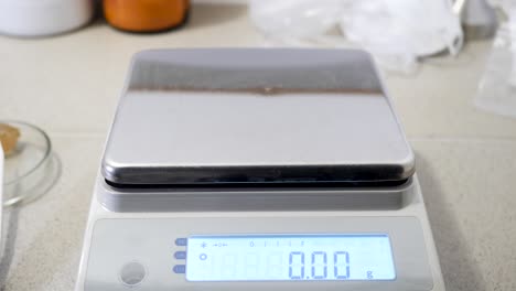 object being weighed on a digital scale in a laboratory setting