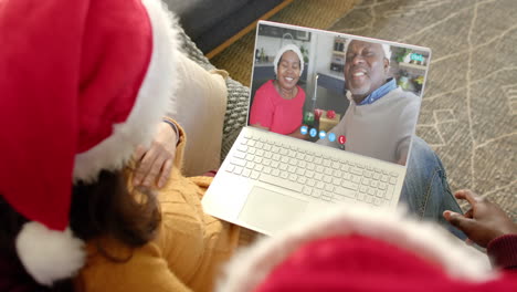 Feliz-Pareja-Diversa-Y-Padres-Mayores-Teniendo-Videollamada-Navideña-Con-Laptop,-Cámara-Lenta