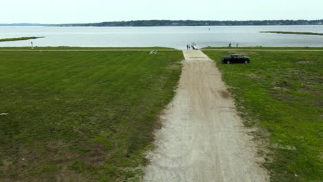 jib motion down over a gravel road leading to a lakeshore