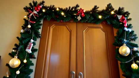 red gift boxes are placed under a beautifully decorated apartment door, creating a festive atmosphere for christmas