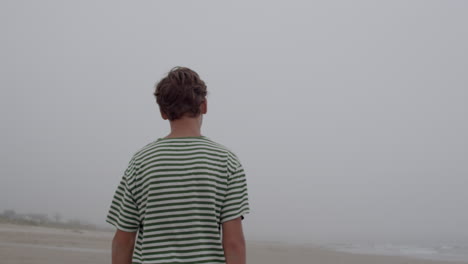 man walking on a foggy beach