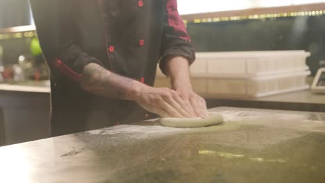 chef kneading pizza dough