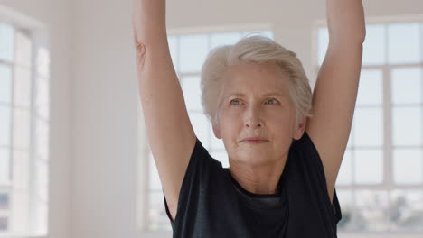 Porträt-Einer-Schönen-Alten-Frau-Im-Yoga-Kurs,-Die-Kriegerpose-Praktiziert-Und-Das-Körperliche-Fitnesstraining-In-Der-Gruppe-Im-Studio-Genießt