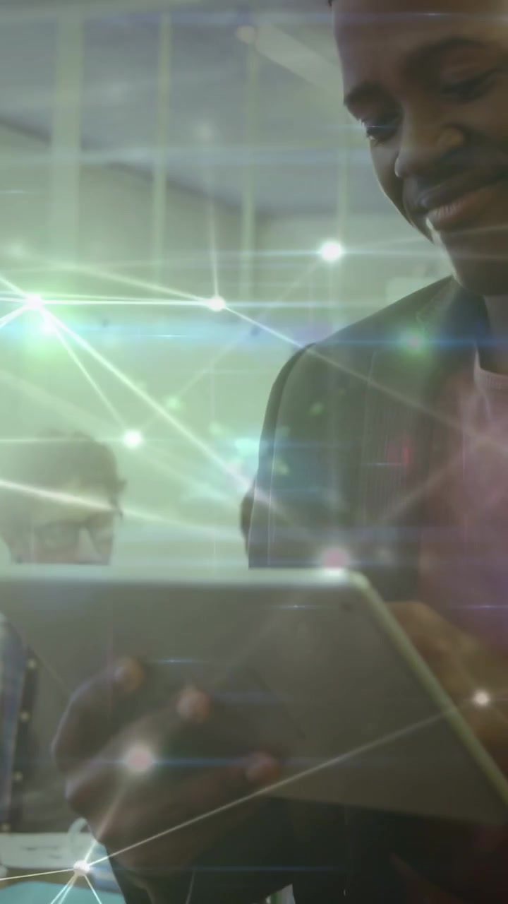 Vertikal video: Mandlig designer tager en tablet og tapper, mens han gennemgår layouts med et lyst overlay.