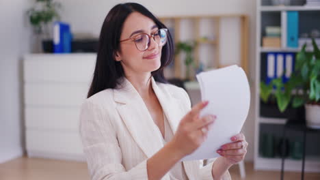 mujer de negocios orgullosa revisando informes financieros y documentos