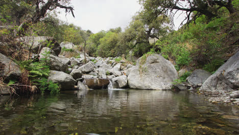 Beautiful-waterfall-flows-to-wild-pond-In-the-forest