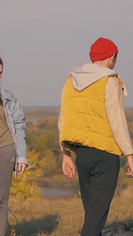pretty girls look at guy suffering from hangover and walking to burning bonfire in early morning slow motion