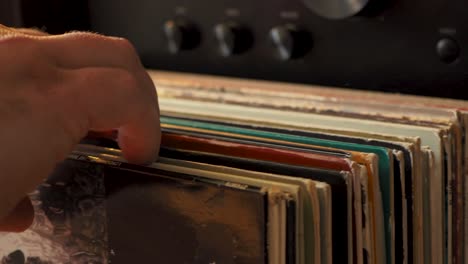 close up man hands browsing vintage vinyl records at home