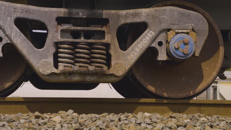 very close shot of rusty train wheels rolling along the train tracks