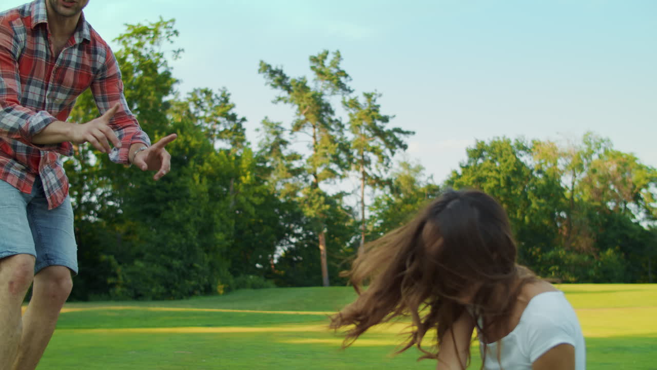 행복 한 여자 와 남자 가 공원 에서 공 을 치고 있다. 소년 은 부모 와 함께 공 을 치고 있다