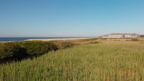 Low-flying-drone-shot-of-sand-dunes,-marsh-and-creeks-in-Oak-Island-NC-shot-in-4k