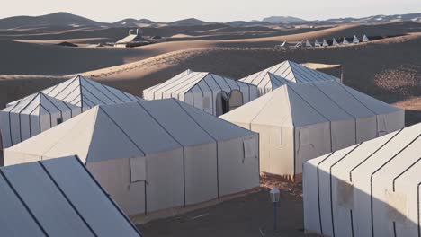 Campamento-Sahara-De-Tiendas-Blancas-En-El-Desierto-Caliente-Del-Sahara,-Vista-De-Movimiento-Portátil