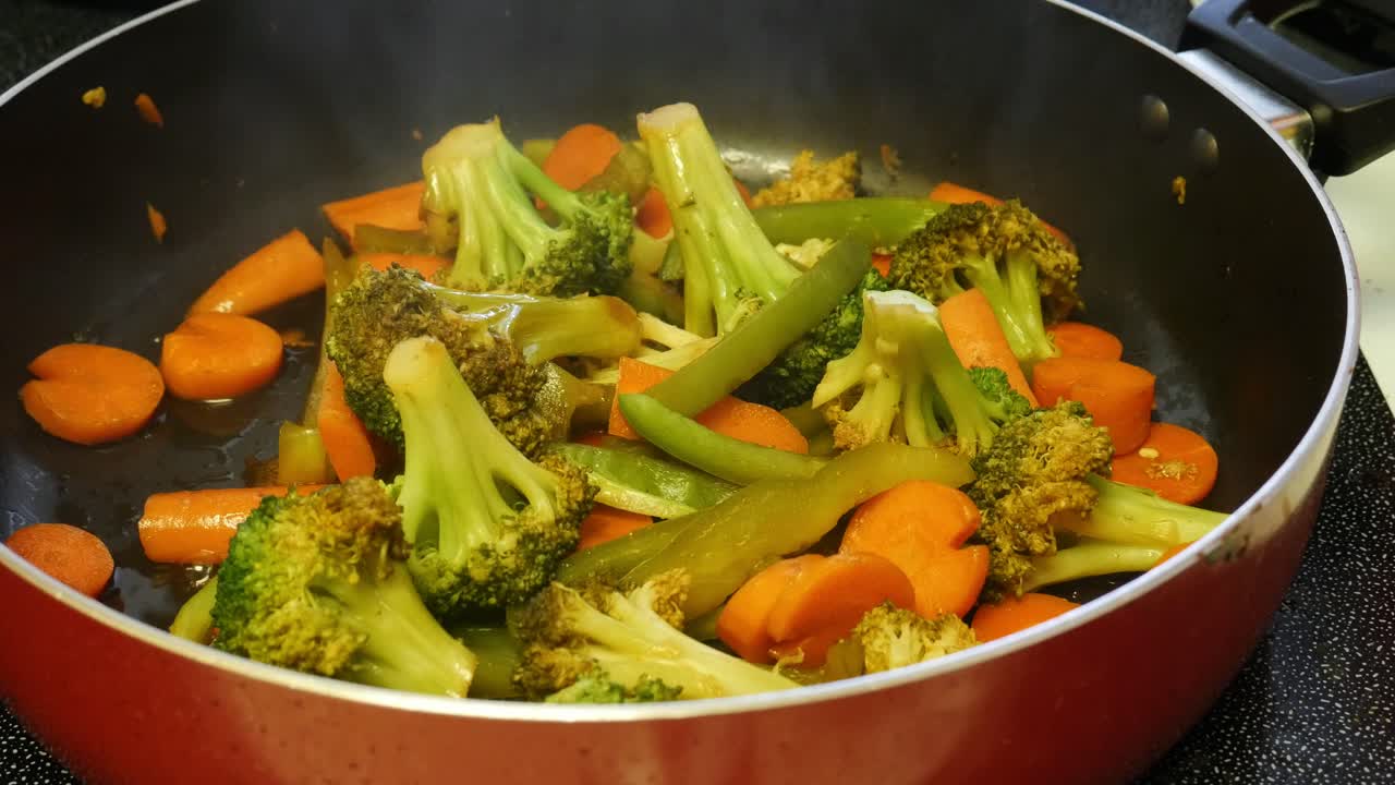mixing vegetables as they cook in a pan