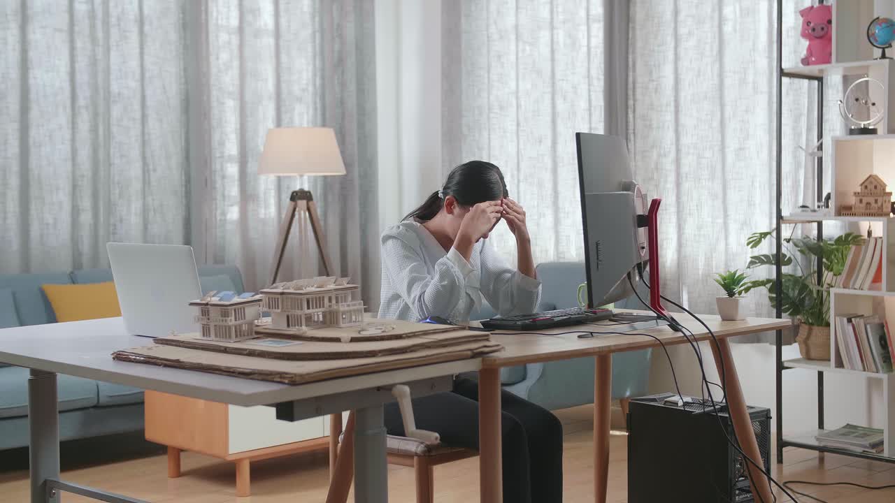 집에서 데스크에서 일하는 동안 두통을 고 있는 하우스 모델과 함께 아시아 여성 엔지니어