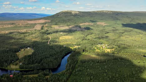 countryside landscape with lush vegetation, lake and green mountain in sälen, dalarna, sweden - aerial drone shot