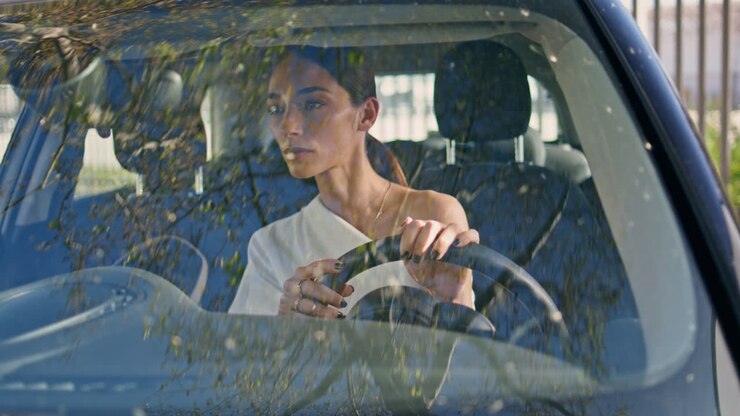 Elegant driver sitting automobile looking mirror correcting makeup close up.