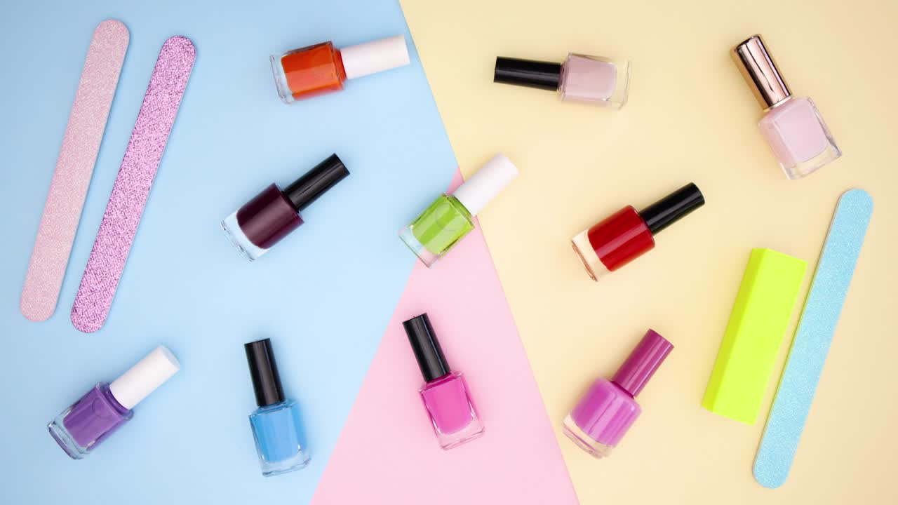 esmalte de uñas y archivos parpadeando en fondo de color - detenga el movimiento