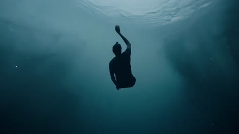 man struggles underwater, reaching desperately for the surface as he faces the terrifying reality of drowning