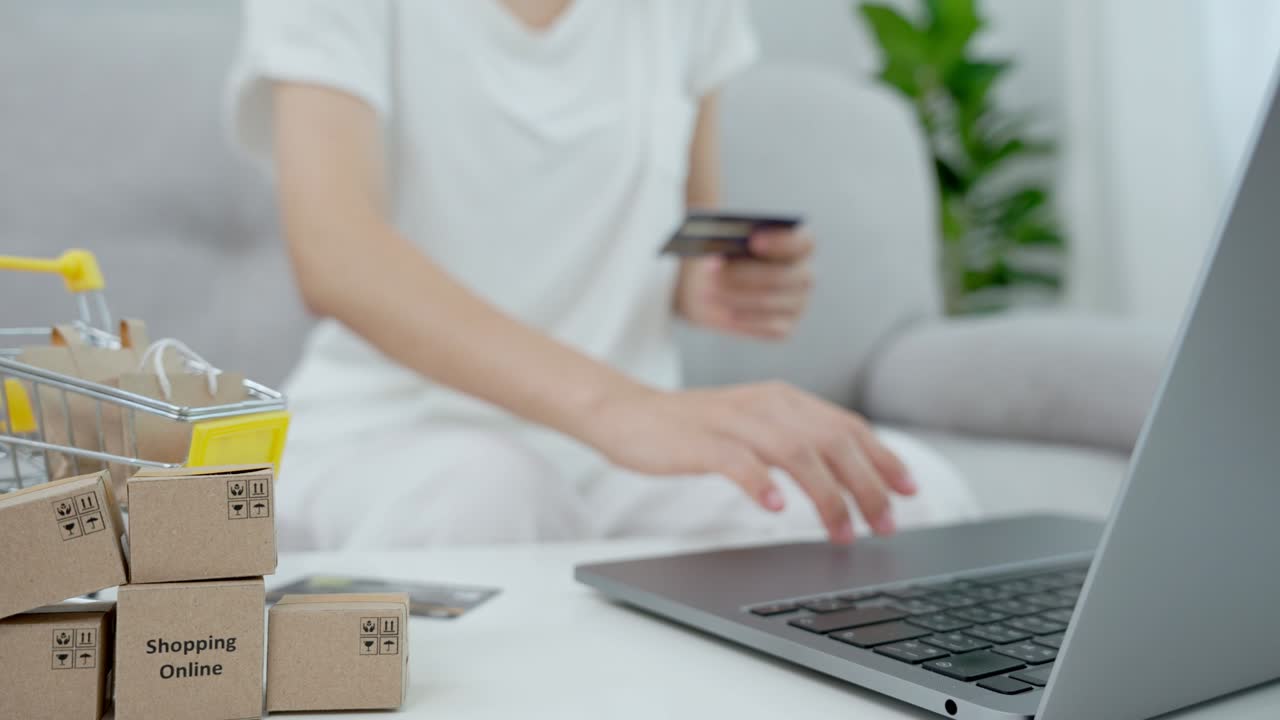 азиатские женщины платят онлайн с помощью кредитной карты и покупают то, что им нравится, на своих компьютерах дома.