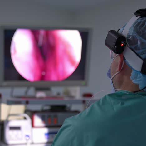 doctor standing with his back to the camera and looking at the screen. surgeon performing operation looks at the screen showing inner organs. close up