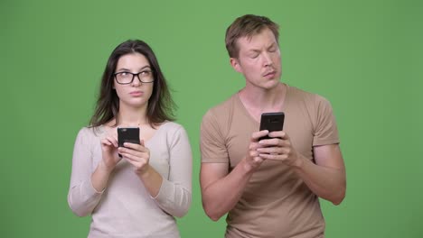 young couple using phone and thinking together