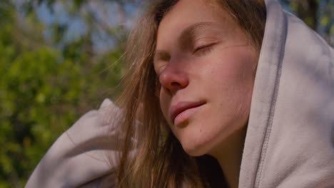 happy and relaxed caucasian female, takes off hood , outdoors closeup